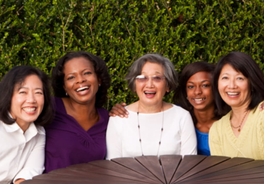 5 women sitting together smiling